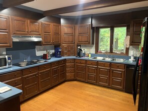 Enjoy cooking in this well-lit kitchen with a microwave and stainless steel sink.