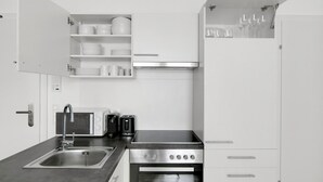 Een moderne keuken met een ingebouwde oven, een koffiezetapparaat, een broodrooster en een spoelbak.