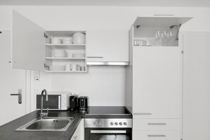 Uma cozinha moderna com forno embutido, cafeteira, torradeira e pia.