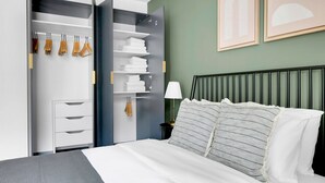 Een moderne slaapkamer met een bed, een garderobe en een nachtkastje.