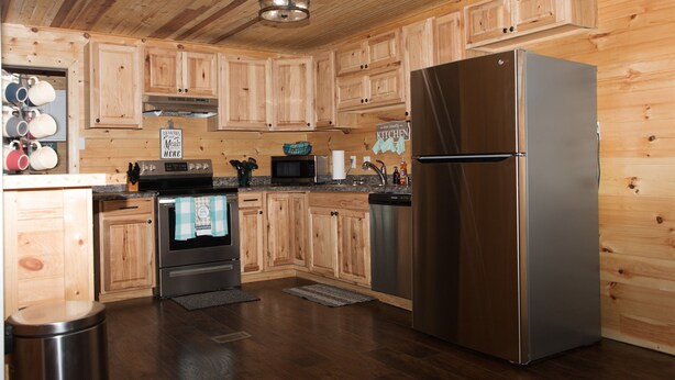 A modern kitchen with wooden cabinets, stainless steel appliances, and a granite countertop.