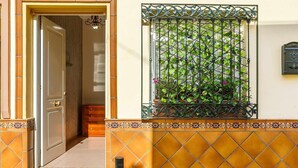 A doorway leading into a room with a tiled floor, a potted plant on a balcony, and a wall-mounted mailbox. - A&n House of the Sun . (Torre del Mar)