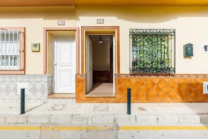 Residential building with a unique architectural style, featuring a combination of tiled and stucco walls.