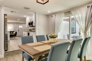 A dining area with a wooden table, blue chairs, and a vase of flowers.