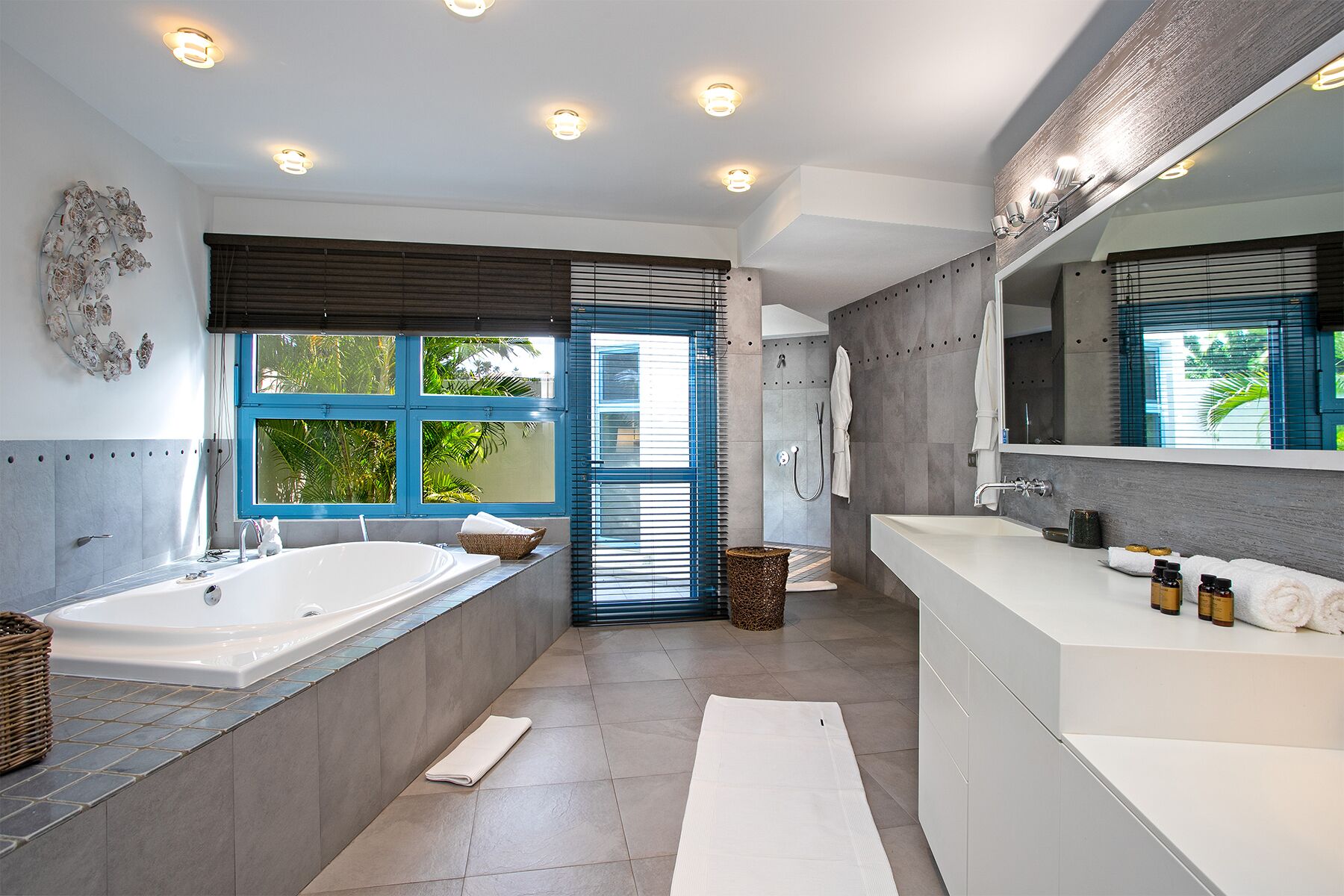 A modern bathroom with a bathtub, a shower, and a vanity with a large mirror.