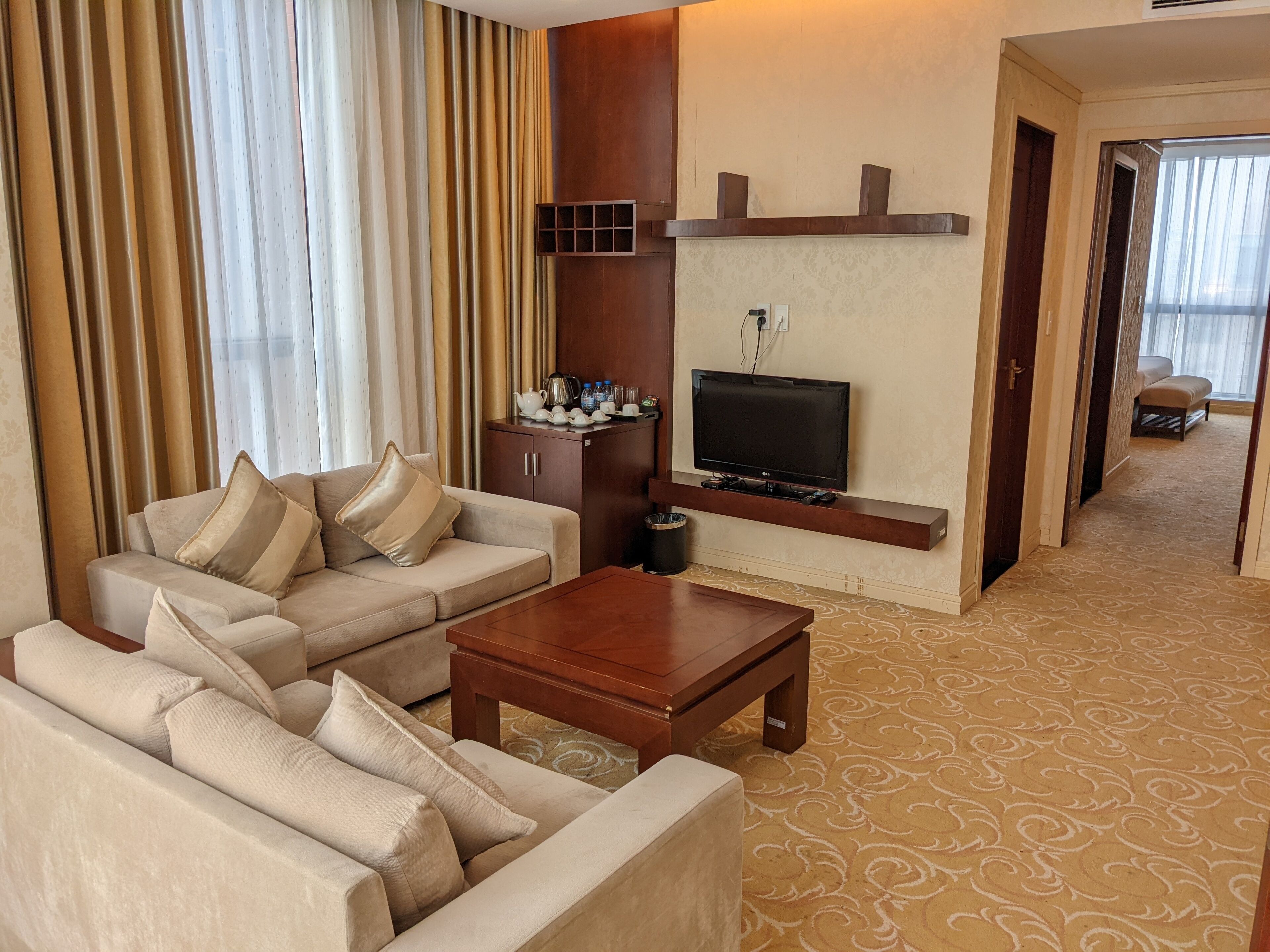 A living room with a sofa, a coffee table, a TV, and a cabinet.