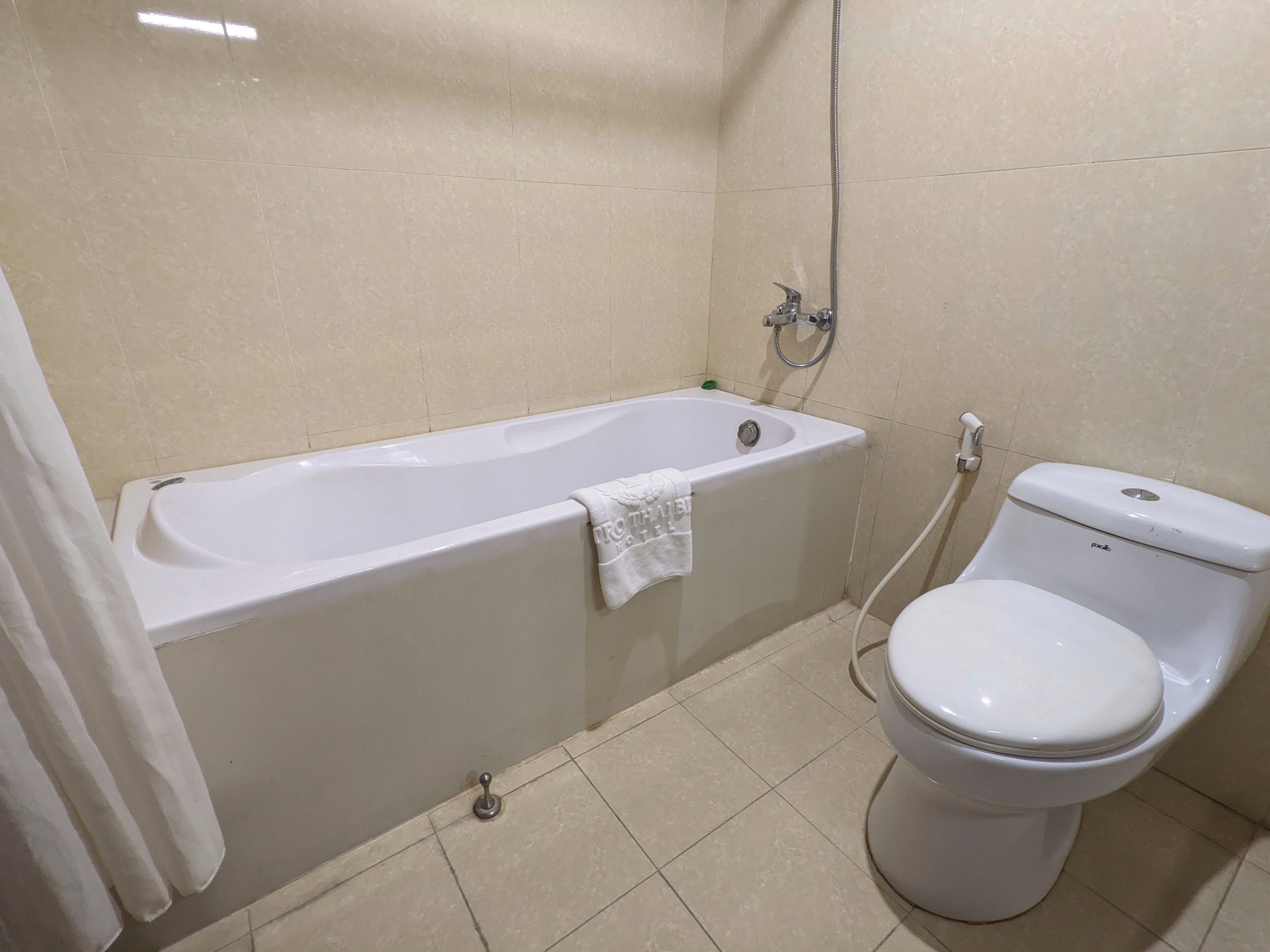 A bathroom with a bathtub, toilet, and shower.