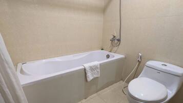 A bathroom with a bathtub, toilet, and shower.