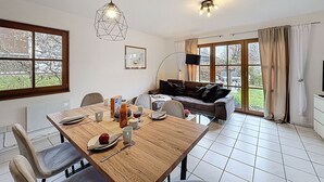 A dining area with a wooden table, chairs, and a hanging light fixture. - Cosy apartment in villa for 6 guests with WIFI, TV, terrace and pets allowed (Bad Wildungen)