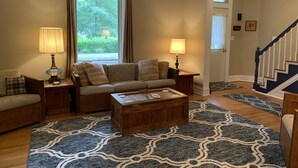 A living room with a sofa, two lamps, a coffee table, and a patterned rug.