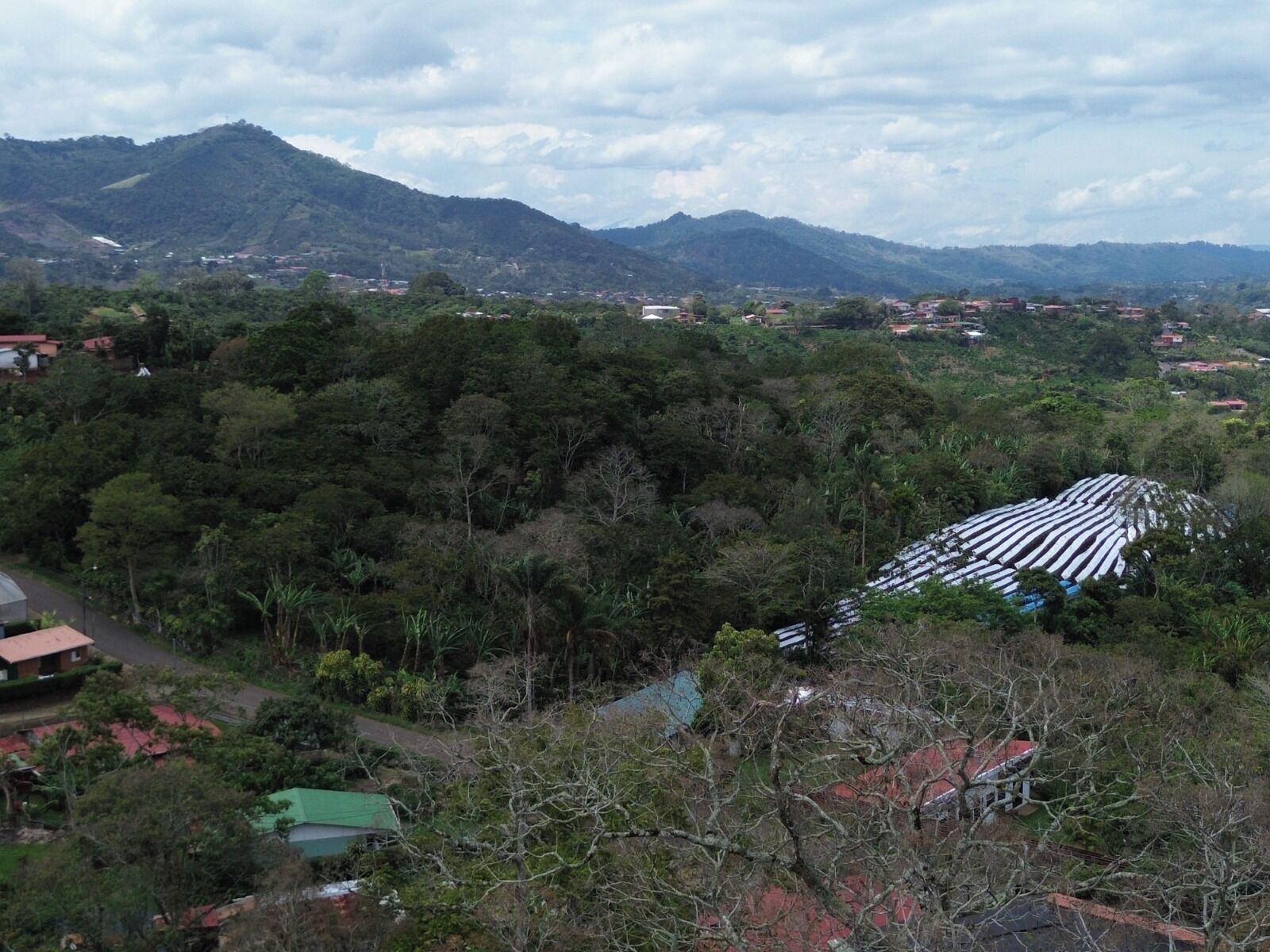 A mountainous landscape with scattered houses and a large white structure.