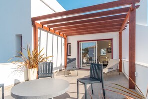 An outdoor patio with a round table and two chairs, a wooden pergola, and a potted plant. - LV Premier LA2 heated pool, AC, garden, sea view (Sesimbra)