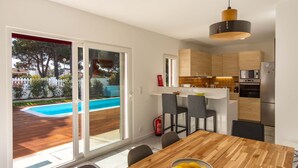 Una cocina moderna con armarios de madera, horno empotrado y microondas.