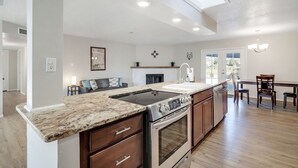 A spacious kitchen with a large island, built-in oven, and a dining area with a wooden table and chairs. - Game Room - Mountain Views - King Bed - near Golf Course - Intel - Rust Medical  (Albuquerque)