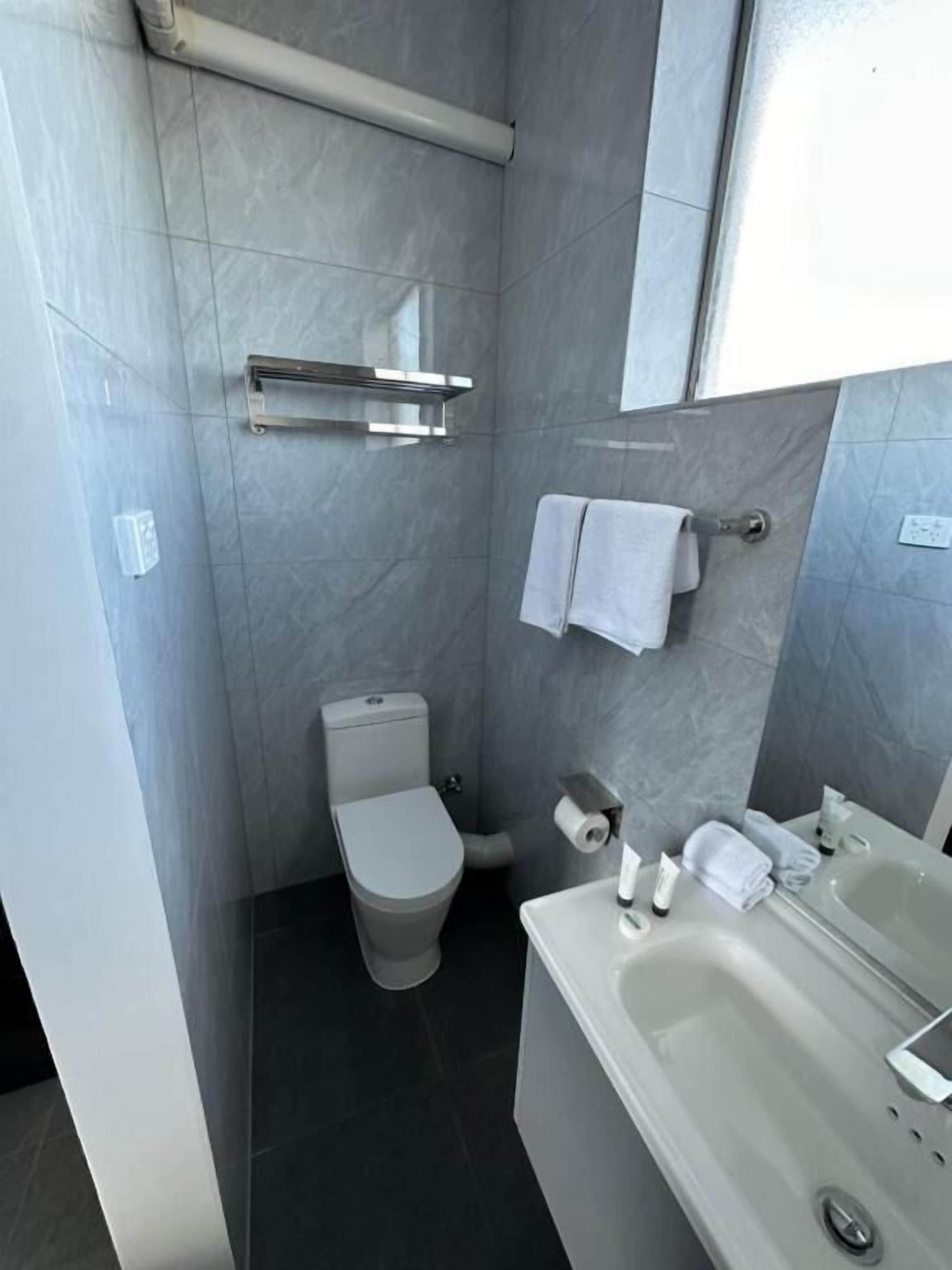 A modern bathroom with a toilet, sink, and bathtub.