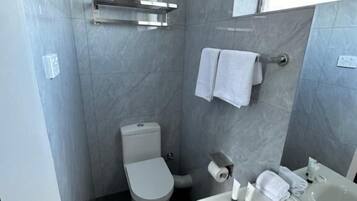 A modern bathroom with a toilet, sink, and bathtub.