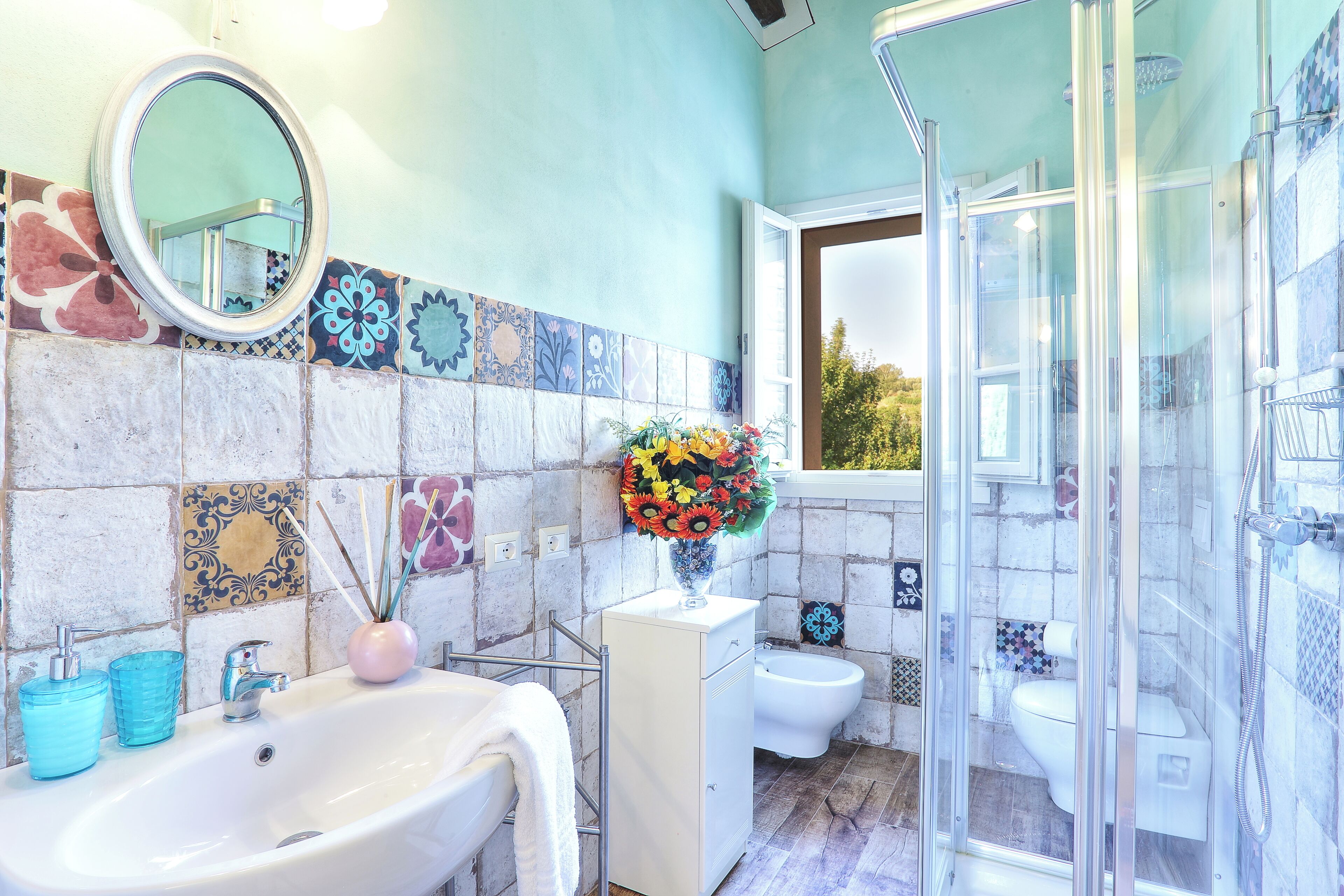 Un baño con lavamanos, espejo y ducha.