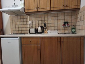 Een koelkast, een koffiezetapparaat/waterkoker, een broodrooster