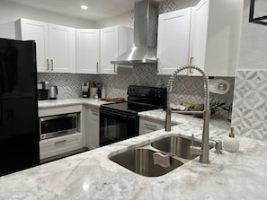 Enjoy cooking in this well-equipped kitchen with a stainless steel sink, coffee maker, and toaster.