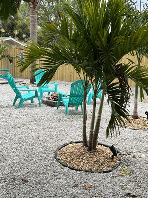 Relax in a tranquil outdoor space surrounded by lush greenery and a palm tree.