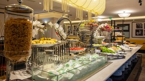 Een buffetopstelling met diverse gerechten en een decoratieve glazen vaas.