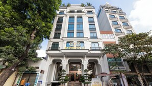 Een hotel met een klassieke architectuur, herkenbaar aan een opvallende entree met treden en een glazen deur.