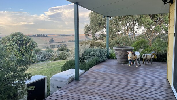 Un espacio exterior cubierto con vistas al campo, una jardinera grande y una fuente de agua.