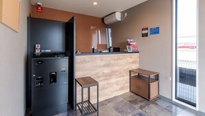 A compact kitchenette with a black refrigerator, a coffee machine, and a small wooden table. - HOTEL R9 The Yard Nakatsu (Nakatsu)