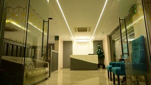 Un moderno vestíbulo de hotel con mostrador de recepción, un árbol de Navidad y zona de estar.