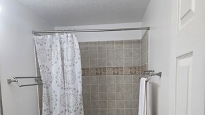 Un baño con inodoro, ducha y bañera.