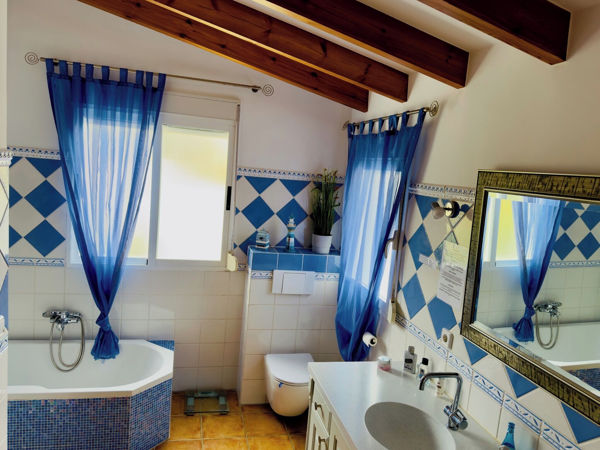 A bathroom with a bathtub, toilet, sink, and a mirror.