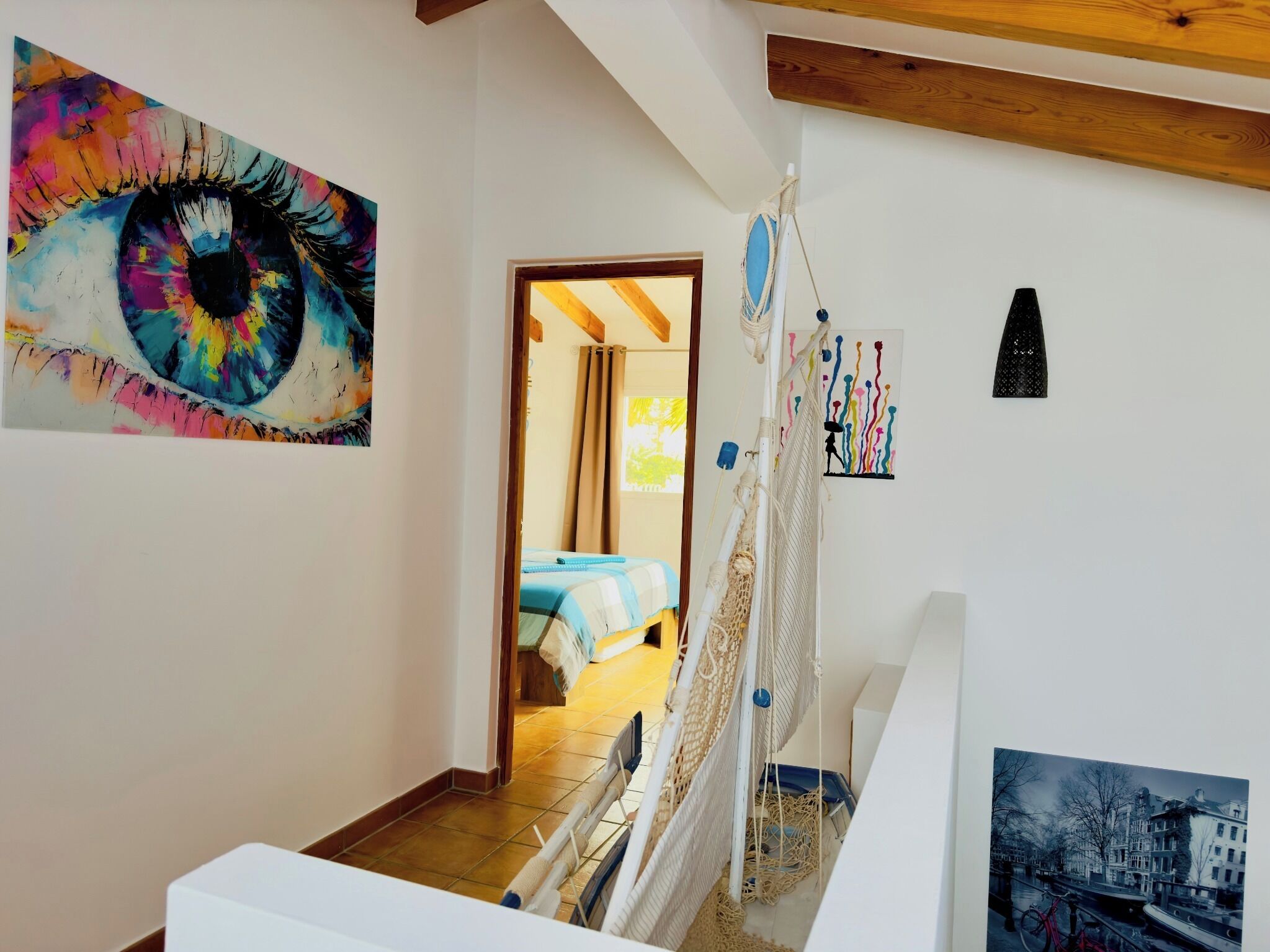 Una habitación con cama, una hamaca y vistas a la ciudad.