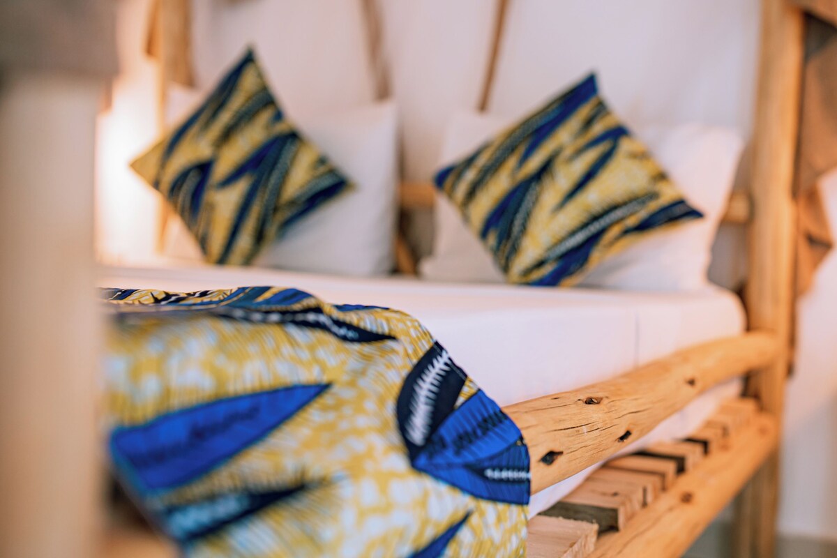 A bed with patterned pillows and a wooden headboard.