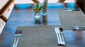Una mesa preparada para comer con vista a la playa y al océano.
