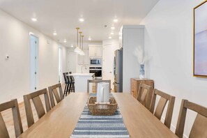 A modern kitchen with white cabinets, a microwave, and a refrigerator.