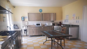 A kitchen with a gas stove, microwave, sink, and stainless steel cabinets. - Independent residence sleeps 32 (Croisilles)