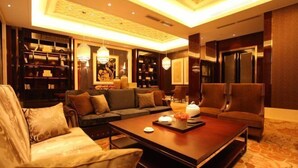 A spacious living room with a large sofa, a coffee table, and a bookshelf.