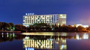 A modern hotel with a reflective pool in front.
