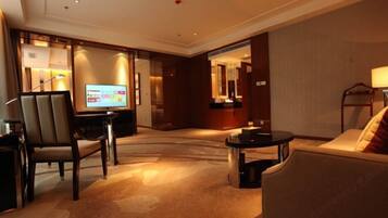 A hotel lobby with a television, seating area, and a reception desk.