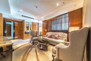 A modern living room with a sofa, armchairs, a coffee table, and a TV. - Doreen Hotel (Lianshui)
