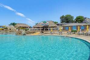 A pool area with a thatched-roof hut labeled "TIKI HUT" and a building with blue shutters.