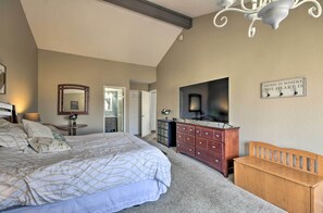 A bedroom with a large bed, a dresser, a bench, a mirror, and a sign on the wall. - Hot Tub! Golfer's Oasis in Margaritaville Resort (Osage Beach)