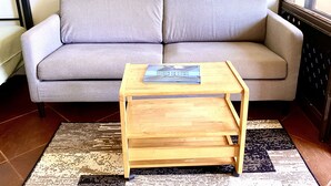 A grey sofa with a wooden coffee table in front. - Stunning ocean view condo (Maunaloa)