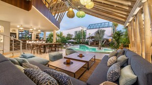 Ein moderner Außenbereich mit Pool, Sitzgelegenheiten und Essbereich.