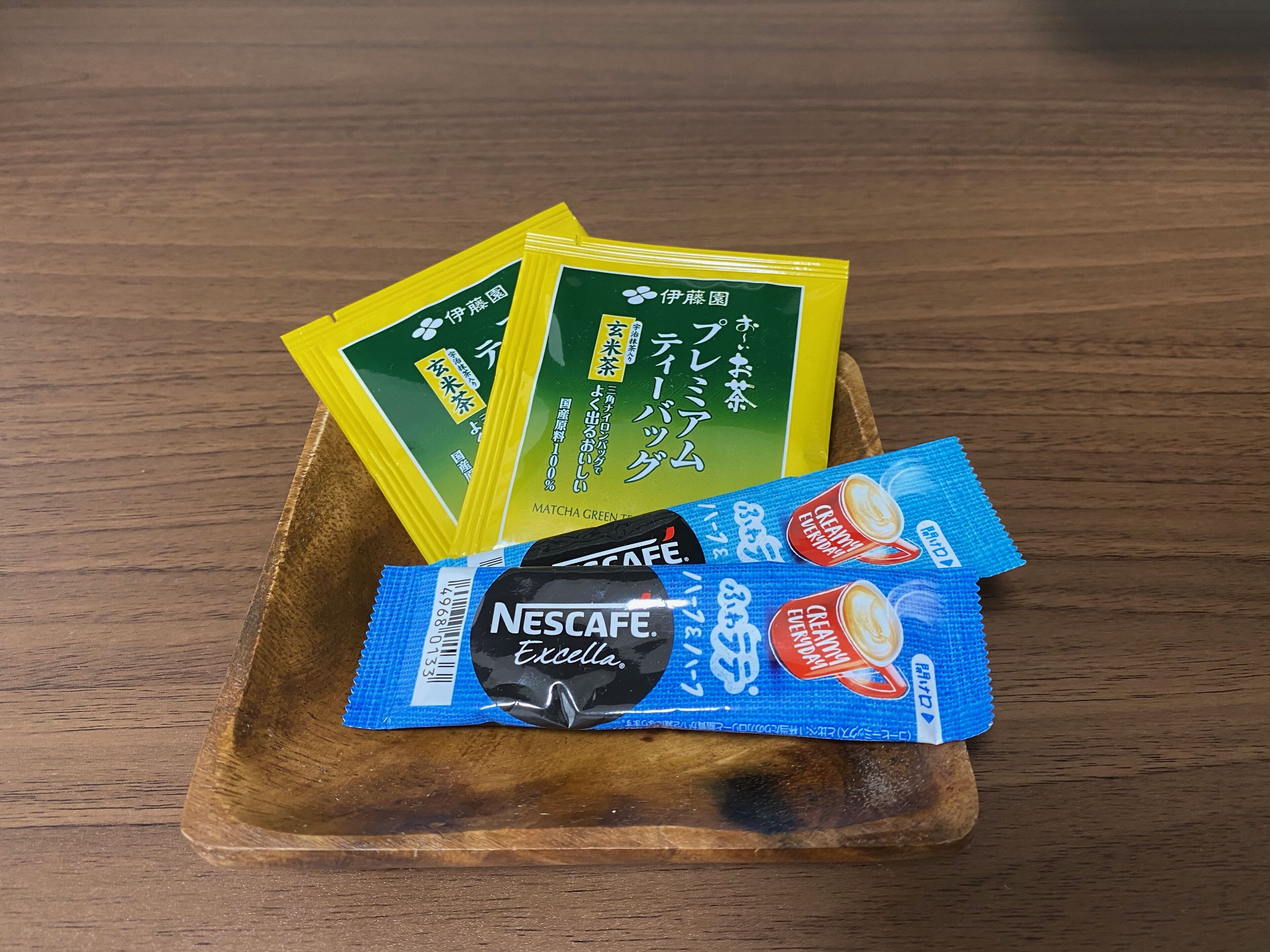 A wooden tray with three packets of Matcha Green Tea and one packet of Nescafe Excella coffee.