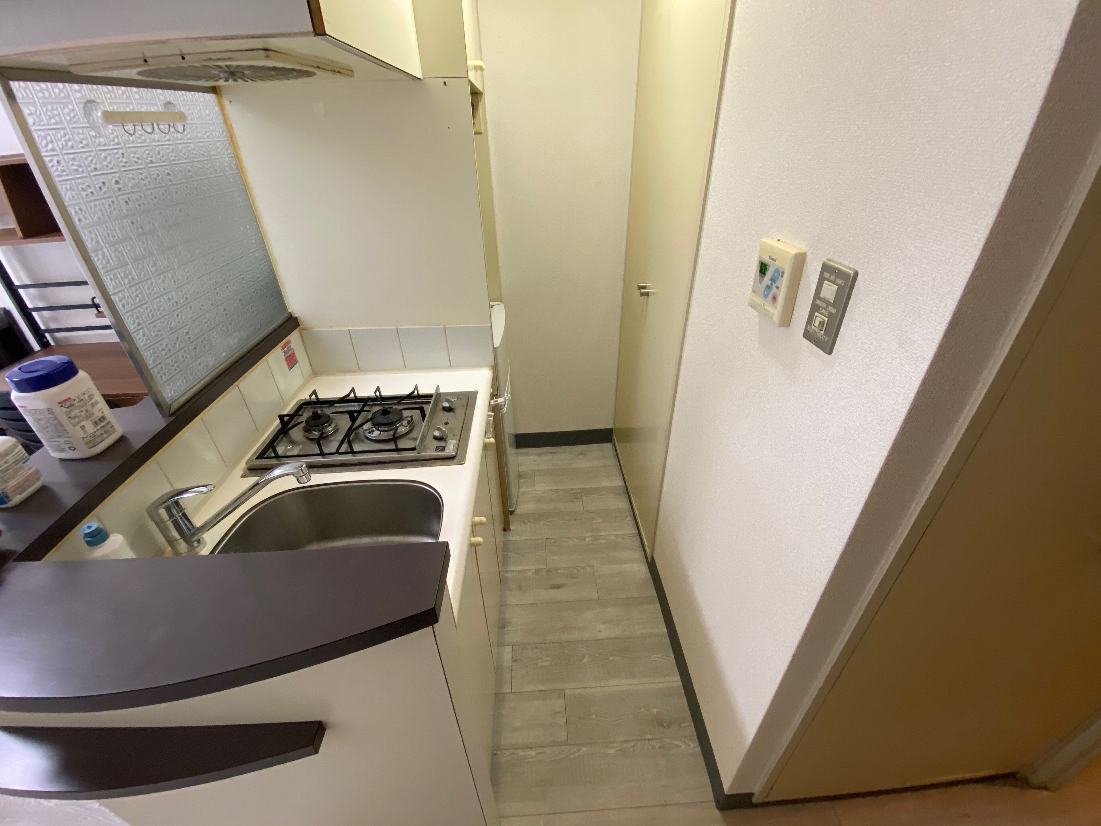 Una cocina compacta con estufa a gas, pileta y una pequeña mesada.