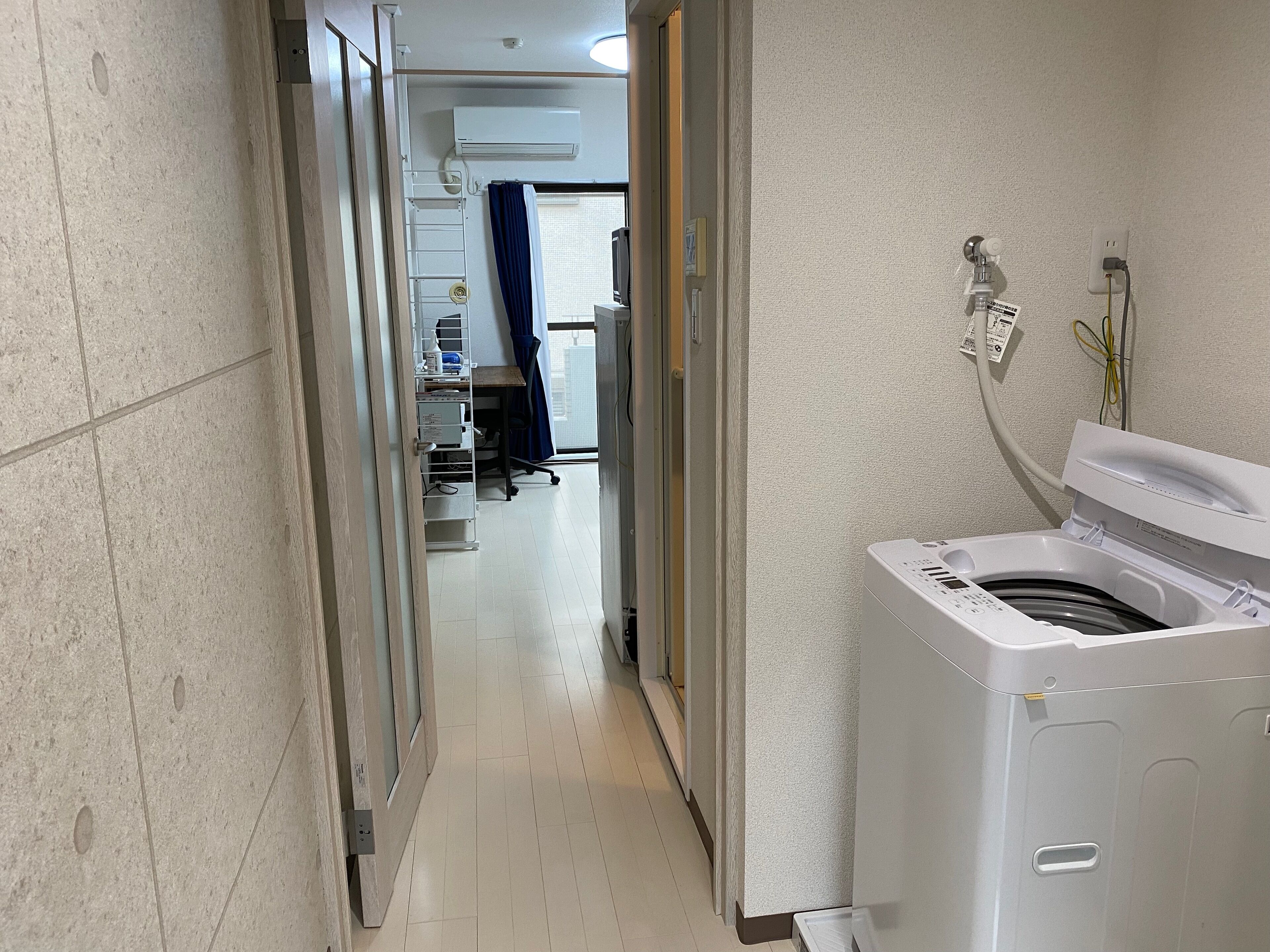 Une buanderie équipée d’un lave-linge, d’un étendoir et d’un chauffe-eau.