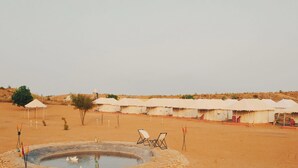 A desert landscape with a water feature, tents, and a small pool. - Treebo Desert Harmony Camp (Jaisalmer)