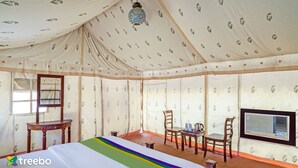 A tented room with a bed, chairs, a table, a television, and a window. - Treebo Desert Harmony Camp (Jaisalmer)