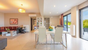 Un salon moderne comprenant un canapé, une table basse et un coin repas avec des chaises et une table.